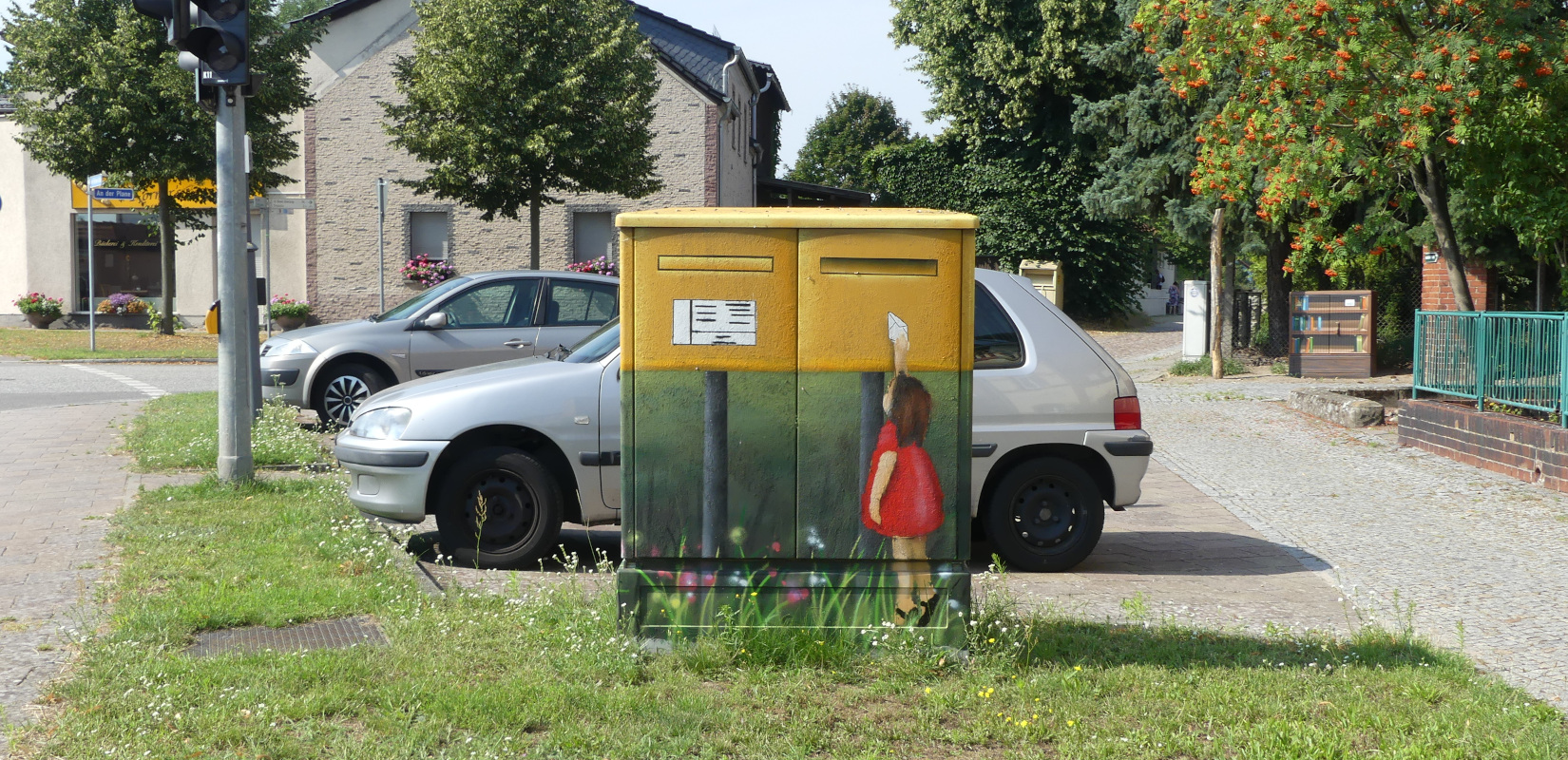 Ein Mädchen mit einem Brief am Briefkasten